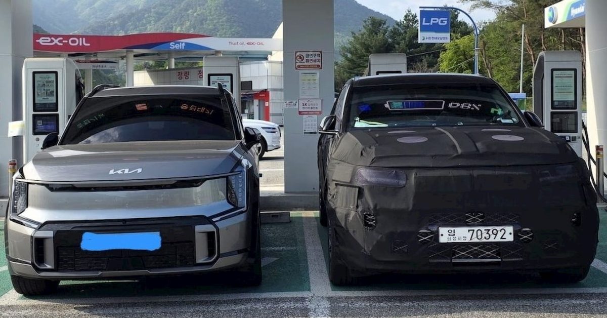 The Genesis GV90 looks huge charging next to the Kia EV9